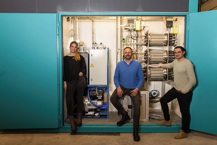 Unser Team vor dem Prototyp unseres Wasserstoff-Energiespeichersystems – die Lösung für autarke und nachhaltige Energieversorgung in Unternehmen.